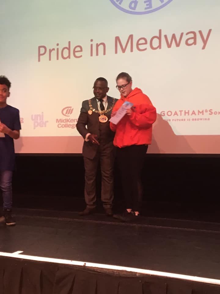 A young volunteer in a Puzzles orange hoodie receiving a certificate from the Mayor at the Pride in Medway awards