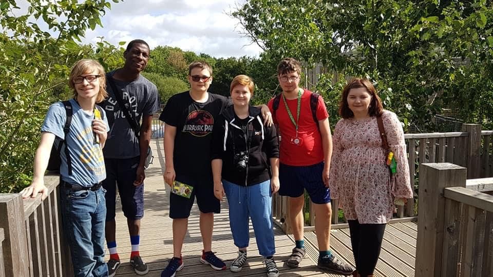 Six Puzzles members on a wooden walkway at a wildlife park